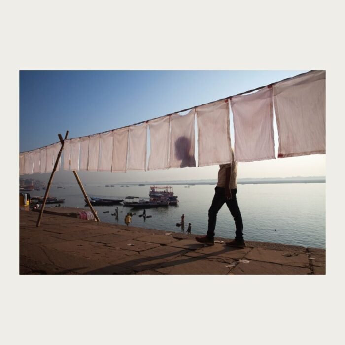 Varanasi ghat with man walking and boat by Bhaskar Kundu